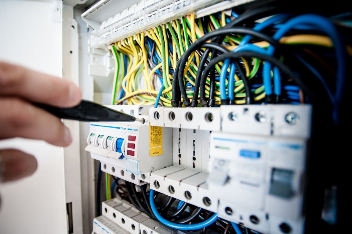 Électricien professionnel intervenant sur un tableau électrique